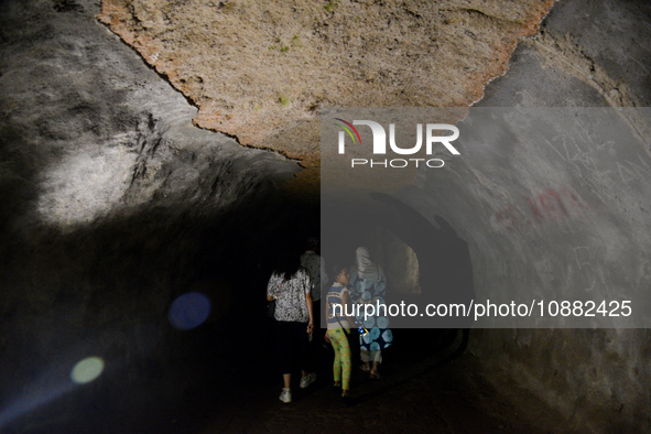 Visitors are walking through the Lobang Jepang (Japanese Tunnel), a historical tourist attraction in Bukittinggi, West Sumatra, Indonesia, o...