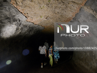 Visitors are walking through the Lobang Jepang (Japanese Tunnel), a historical tourist attraction in Bukittinggi, West Sumatra, Indonesia, o...