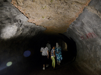 Visitors are walking through the Lobang Jepang (Japanese Tunnel), a historical tourist attraction in Bukittinggi, West Sumatra, Indonesia, o...