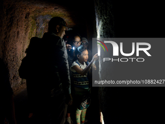 A guide is accompanying tourists as they visit the Japanese tunnel, also known as Lobang Jepang, at the historical tourist attraction in Buk...