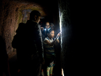 A guide is accompanying tourists as they visit the Japanese tunnel, also known as Lobang Jepang, at the historical tourist attraction in Buk...