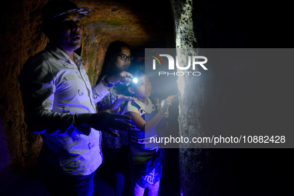 A guide is accompanying tourists as they visit the Japanese tunnel, also known as Lobang Jepang, at the historical tourist attraction in Buk...