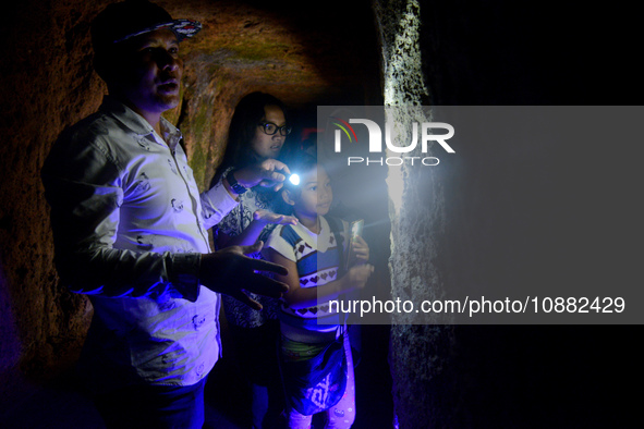 A guide is accompanying tourists as they visit the Japanese tunnel, also known as Lobang Jepang, at the historical tourist attraction in Buk...