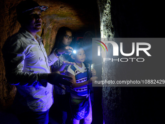 A guide is accompanying tourists as they visit the Japanese tunnel, also known as Lobang Jepang, at the historical tourist attraction in Buk...