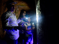 A guide is accompanying tourists as they visit the Japanese tunnel, also known as Lobang Jepang, at the historical tourist attraction in Buk...