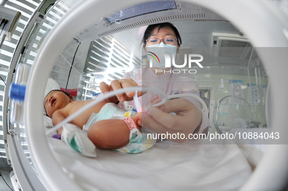 A medical worker is taking care of newborns at Dongfang Hospital in Lianyungang, China, on January 1, 2024. 