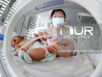 A medical worker is taking care of newborns at Dongfang Hospital in Lianyungang, China, on January 1, 2024. (