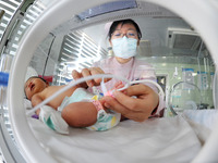 A medical worker is taking care of newborns at Dongfang Hospital in Lianyungang, China, on January 1, 2024. (