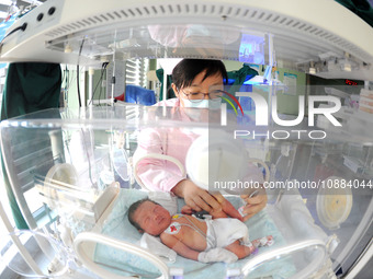 A medical worker is taking care of newborns at Dongfang Hospital in Lianyungang, China, on January 1, 2024. (