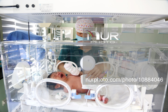 A medical worker is taking care of newborns at Dongfang Hospital in Lianyungang, China, on January 1, 2024. 