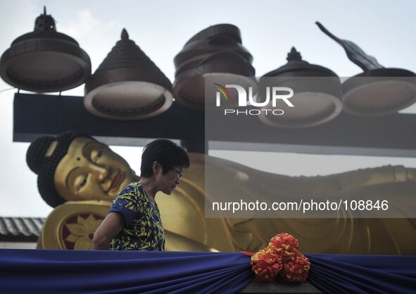 A woman walk past a statue of Buddha during Vesak Day celebrations at a Buddhist temple in Kuala Lumpur, Malaysia on May 13, 2014.

Photo: M...