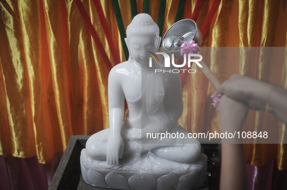 A woman pours water over a statue of Buddha during Vesak Day celebrations at a Buddhist temple in Kuala Lumpur, Malaysia on May 13, 2014.

P...