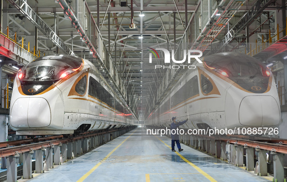 Workers are inspecting an EMU train at the inspection depot of the Nanjing South Bullet Train station in Nanjing, Jiangsu Province, China, o...