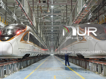 Workers are inspecting an EMU train at the inspection depot of the Nanjing South Bullet Train station in Nanjing, Jiangsu Province, China, o...