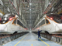 Workers are inspecting an EMU train at the inspection depot of the Nanjing South Bullet Train station in Nanjing, Jiangsu Province, China, o...