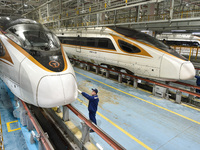 Workers are inspecting an EMU train at the inspection depot of the Nanjing South Bullet Train station in Nanjing, Jiangsu Province, China, o...