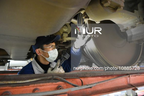 Workers are inspecting an EMU train at the inspection depot of the Nanjing South Bullet Train station in Nanjing, Jiangsu Province, China, o...