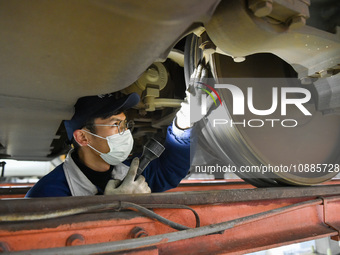 Workers are inspecting an EMU train at the inspection depot of the Nanjing South Bullet Train station in Nanjing, Jiangsu Province, China, o...