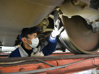 Workers are inspecting an EMU train at the inspection depot of the Nanjing South Bullet Train station in Nanjing, Jiangsu Province, China, o...