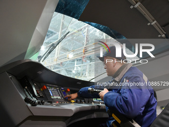 Workers are inspecting an EMU train at the inspection depot of the Nanjing South Bullet Train station in Nanjing, Jiangsu Province, China, o...