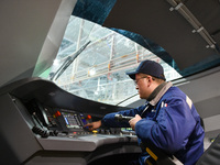 Workers are inspecting an EMU train at the inspection depot of the Nanjing South Bullet Train station in Nanjing, Jiangsu Province, China, o...