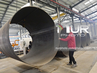 A worker is lifting equipment at a workshop of an equipment manufacturing enterprise in the Qingzhou Economic Development Zone in Qingzhou,...