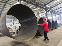 A worker is lifting equipment at a workshop of an equipment manufacturing enterprise in the Qingzhou Economic Development Zone in Qingzhou,...