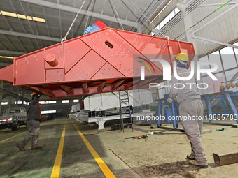 A worker is lifting equipment at a workshop of an equipment manufacturing enterprise in the Qingzhou Economic Development Zone in Qingzhou,...