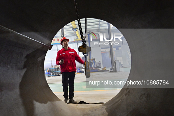 A worker is lifting equipment at a workshop of an equipment manufacturing enterprise in the Qingzhou Economic Development Zone in Qingzhou,...