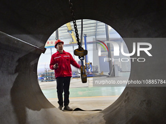 A worker is lifting equipment at a workshop of an equipment manufacturing enterprise in the Qingzhou Economic Development Zone in Qingzhou,...