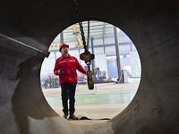 A worker is lifting equipment at a workshop of an equipment manufacturing enterprise in the Qingzhou Economic Development Zone in Qingzhou,...