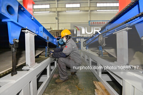 A worker is assembling equipment at a workshop of an equipment manufacturing enterprise in the Qingzhou Economic Development Zone, in Qingzh...