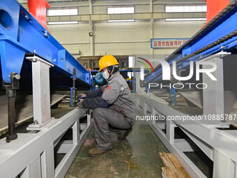 A worker is assembling equipment at a workshop of an equipment manufacturing enterprise in the Qingzhou Economic Development Zone, in Qingzh...