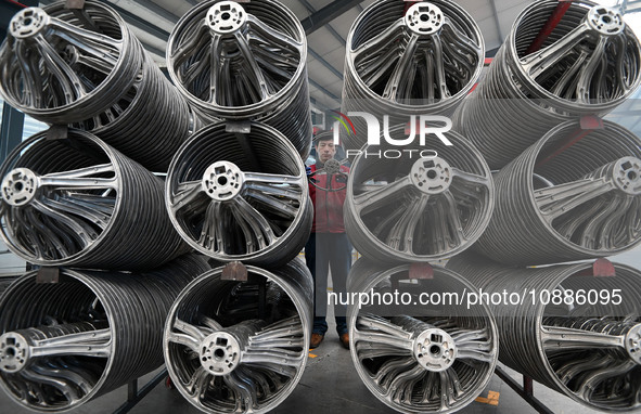 A worker is checking the quality of a car steering wheel frame at a company in Handan, China, on January 2, 2024. 