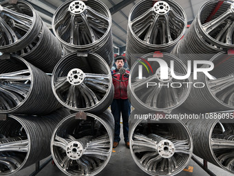 A worker is checking the quality of a car steering wheel frame at a company in Handan, China, on January 2, 2024. (