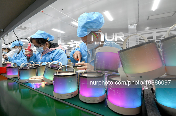 A worker is working on a production line of Bluetooth headsets at an audio equipment manufacturing company in Handan, Hebei Province, China,...