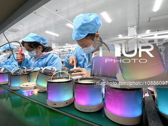 A worker is working on a production line of Bluetooth headsets at an audio equipment manufacturing company in Handan, Hebei Province, China,...