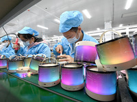 A worker is working on a production line of Bluetooth headsets at an audio equipment manufacturing company in Handan, Hebei Province, China,...