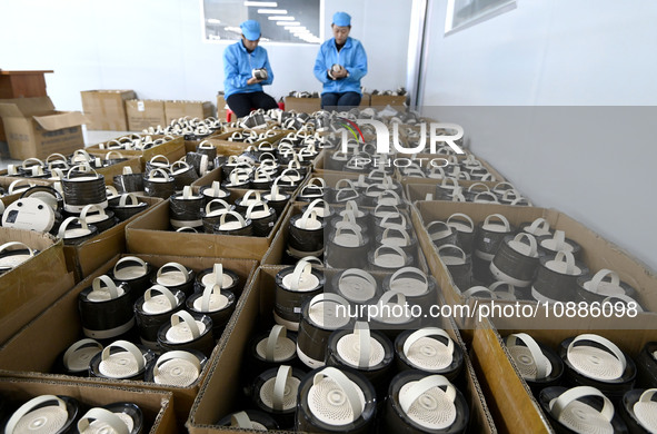 Workers are checking the quality of Bluetooth audio at an audio equipment manufacturing company in Handan, Hebei Province, China, on January...