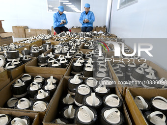 Workers are checking the quality of Bluetooth audio at an audio equipment manufacturing company in Handan, Hebei Province, China, on January...