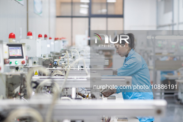 A worker is producing electronic products at a company in Xinghua, Jiangsu Province, China, on January 2, 2024. 