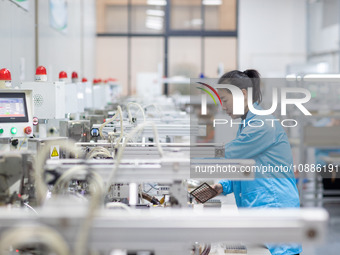 A worker is producing electronic products at a company in Xinghua, Jiangsu Province, China, on January 2, 2024. (