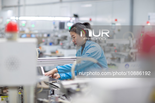 A worker is producing electronic products at a company in Xinghua, Jiangsu Province, China, on January 2, 2024. 