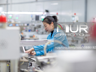 A worker is producing electronic products at a company in Xinghua, Jiangsu Province, China, on January 2, 2024. (