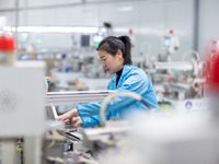 A worker is producing electronic products at a company in Xinghua, Jiangsu Province, China, on January 2, 2024. (