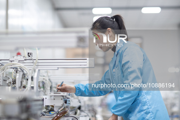 A worker is producing electronic products at a company in Xinghua, Jiangsu Province, China, on January 2, 2024. 