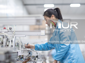 A worker is producing electronic products at a company in Xinghua, Jiangsu Province, China, on January 2, 2024. (