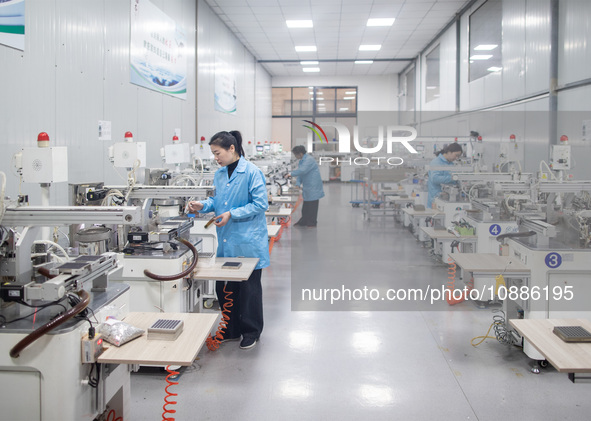 A worker is producing electronic products at a company in Xinghua, Jiangsu Province, China, on January 2, 2024. 