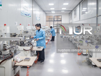 A worker is producing electronic products at a company in Xinghua, Jiangsu Province, China, on January 2, 2024. (