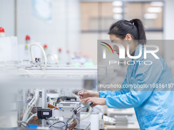 A worker is producing electronic products at a company in Xinghua, Jiangsu Province, China, on January 2, 2024. (